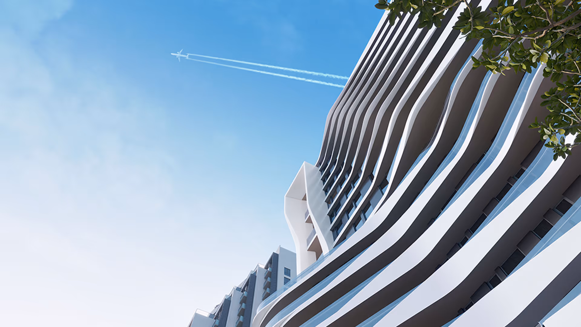A plane flying over a building with a curved facade - Sabah Residence